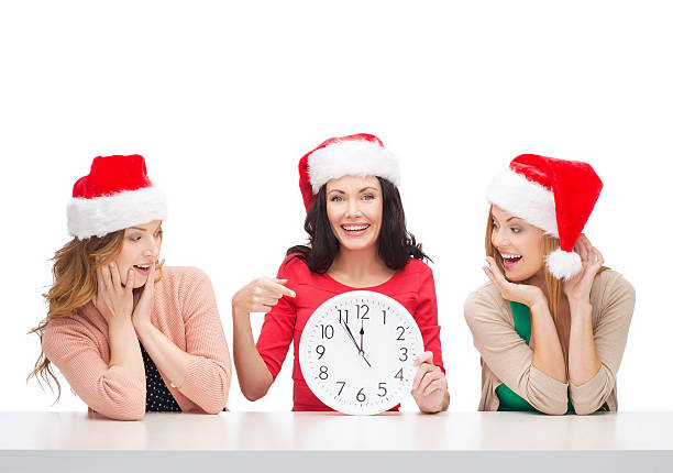 istock women in santa helper hats with clock showing 12 456867051