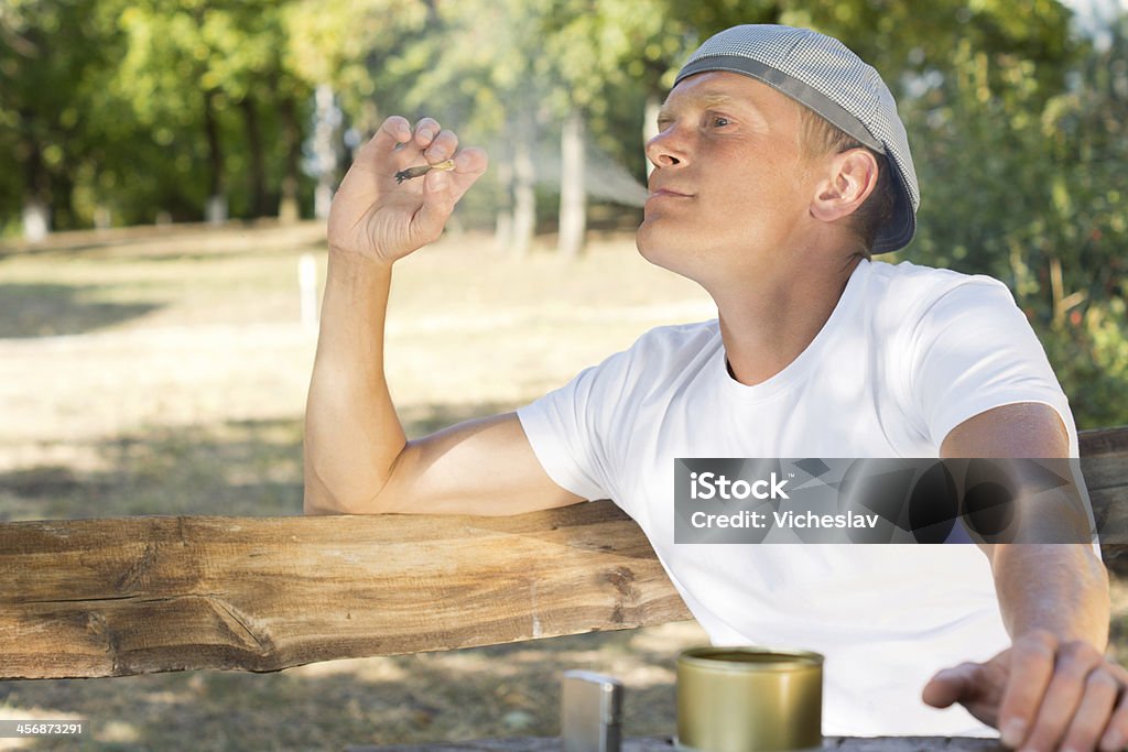 Uomo sbuffano su della marijuana o di cannabis sigaretta - Foto stock royalty-free di Abuso di sostanze