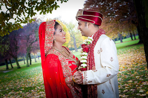 Newly married Indian couple embracing in the serene parkland stock photo