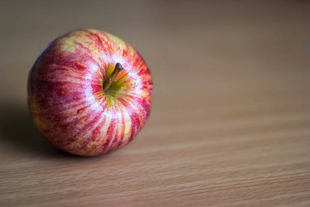 istock Red apple on wooden table with gray wall 456897787