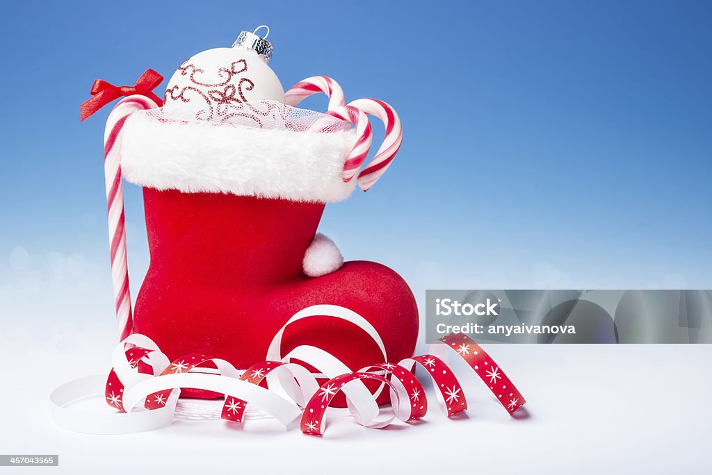 Santa's boot with candy canes, text space Santa's boot with candy canes and Xmas decorations on blue gradient background, text space Blue Background Stock Photo