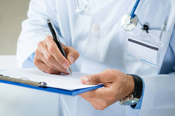мужской доктор писать на медицинский документ - clipboard стоковые фото и изображения