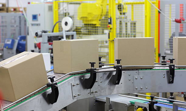 istock automation - Cardboard boxes on conveyor belt in factory 457047995