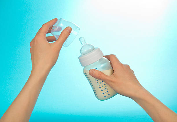 istock Small bottle with milk in female hands 457065031