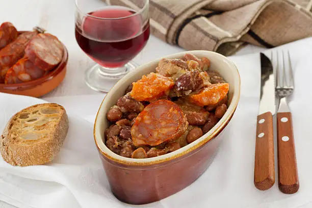 sausages and meat with red beans and glass of red wine