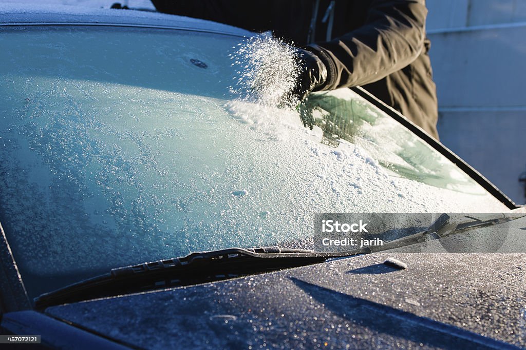 Cleans frozen windshield A man cleans frozen windshield by scratching, cold morning Car Stock Photo