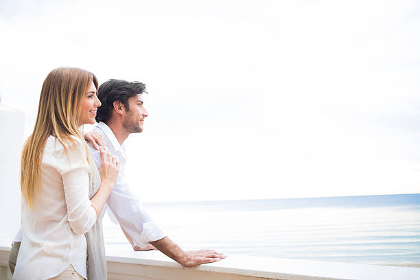 istock happy couple looking at the sea 457074267