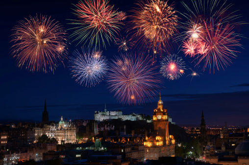 New Years fireworks over the city of Edinburgh with major famous attractions such as the Castle, Princes Street and other heritage buildings.