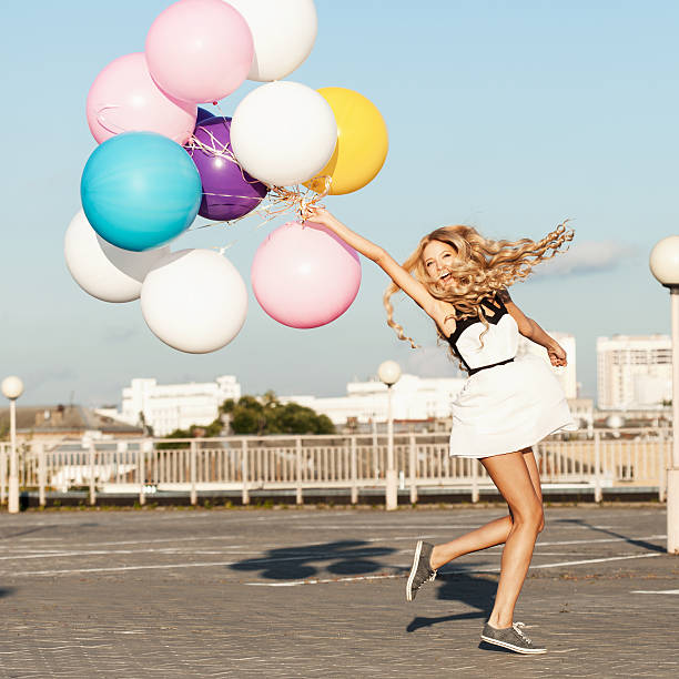 Happy young woman with colorful latex balloons stock photo