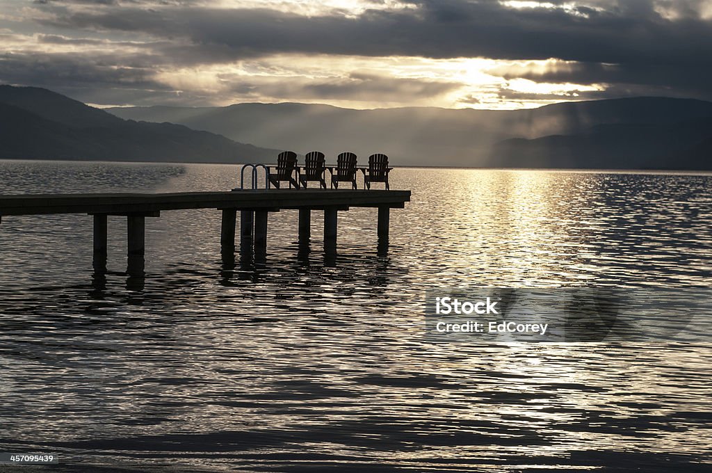 Sun Set on Lake Okanagan Deck Chairs on a dock at Sun Set on Lake Okanagan Backgrounds Stock Photo