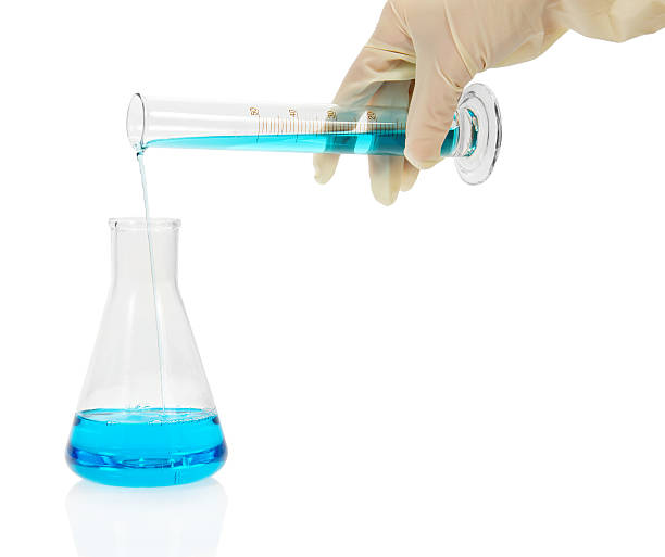 istock The flask with blue liquid, a hand holds measured tube 457147651
