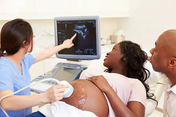 Photo of Pregnant Woman And Partner Having 4D Ultrasound Scan
