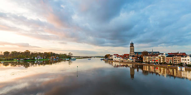 Panoramic river view of the Dutch historic city Deventer Panoramic view of the Dutch IJssel river with the historic city Deventer reflected in the water ijssel stock pictures, royalty-free photos & images