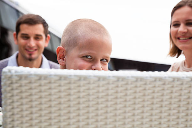 istock brave bald smiling boy recovering from illness with parents 457206757