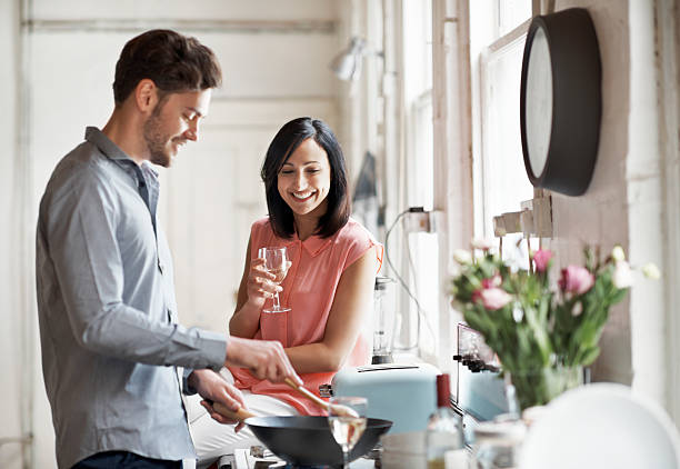 couple cooking together - stove top photos et images de collection