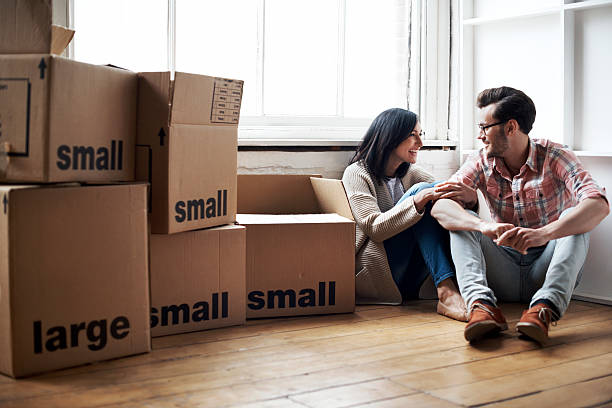 couple moving into new flat - moving house apartment couple box imagens e fotografias de stock