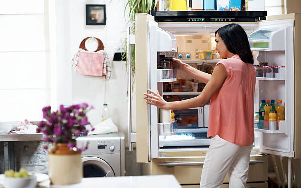 woman looking in the fridge - frigo ouvert photos et images de collection