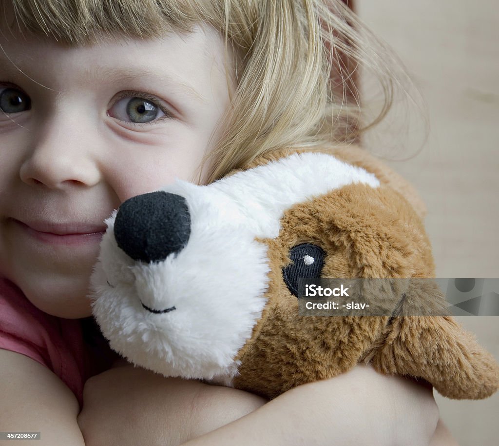 little girl cuddling with a toy dog closeup portrait of a little girl cuddling with a toy dog Dog Stock Photo