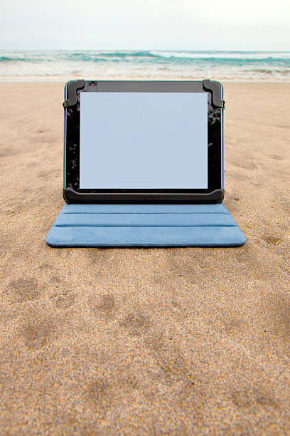 istock Tablet device on the beach by an ocean 457269173