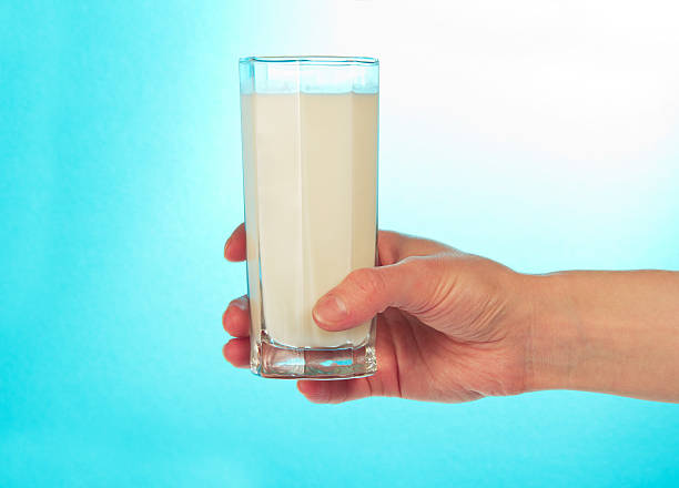 istock Glass of fresh cold milk in hand 457279689