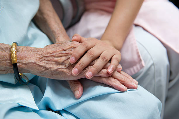 istock Young and old people comforting each other by holding hands 457342679