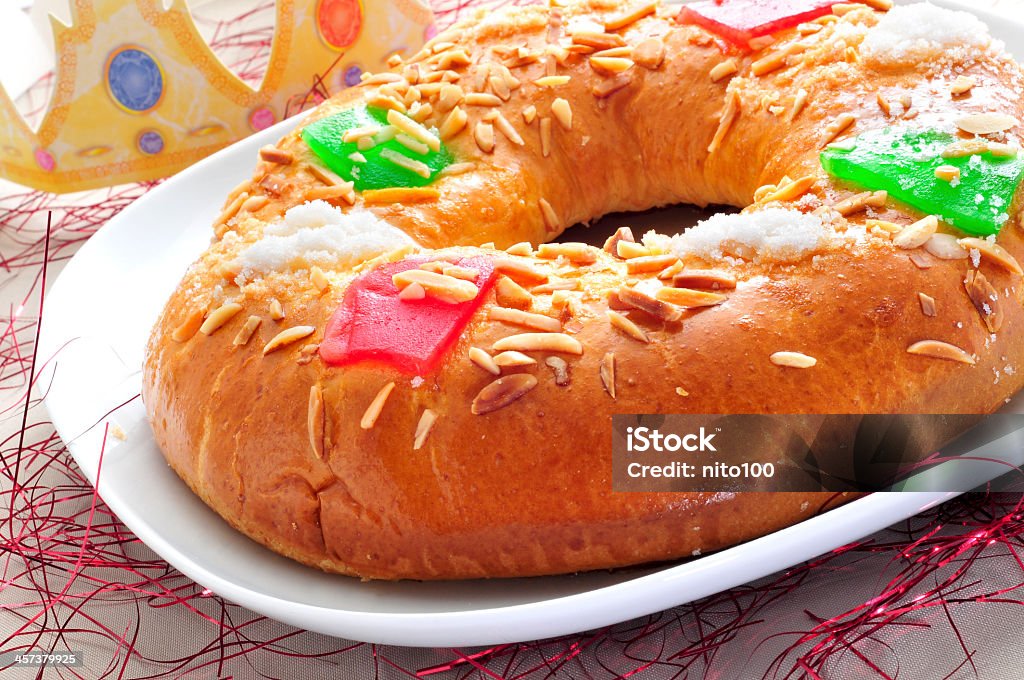 Spanish three kings cake, roscon de reyes on white plate roscon de reyes, spanish three kings cake eaten on epiphany day Rosca De Reyes Stock Photo