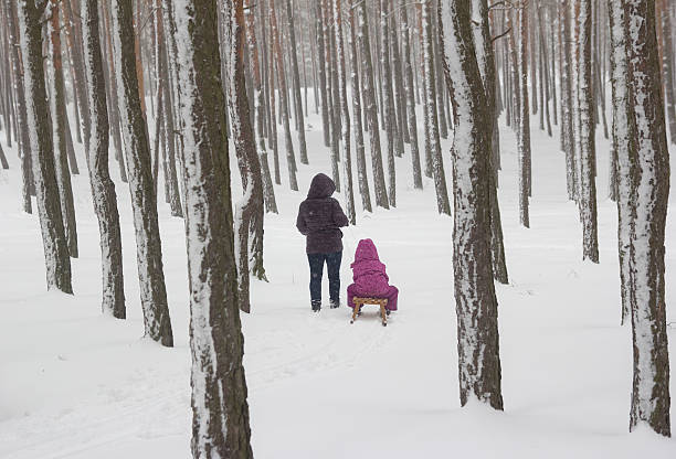 istock woman witch child on sledge in the forest 457392255