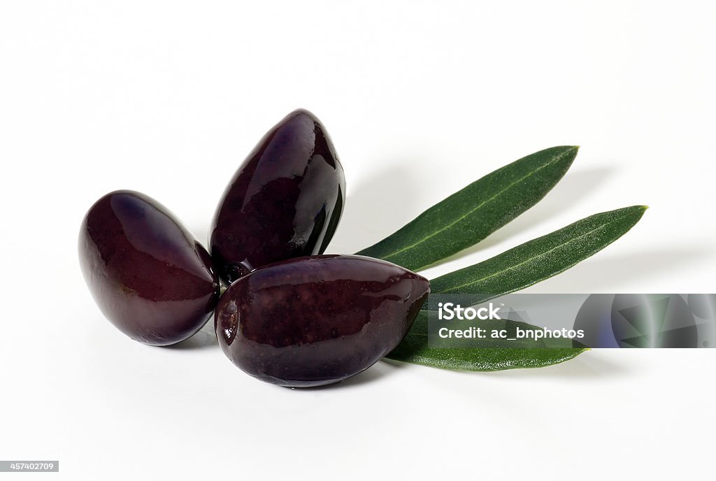 Calamata olives(+clipping path) Three Calamata olives with leaves on white background with clipping path. Kalamata Olive Stock Photo