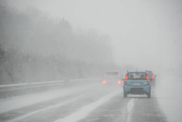 istock Machines on the winter road to a snow storm 457403179