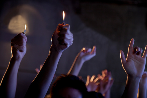 Group of people holding cigarette lighters at a concert