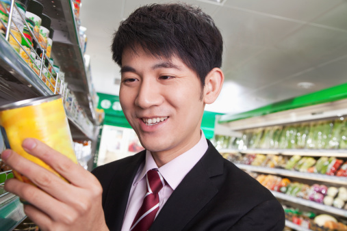 Businessman looking at can in the  Supermarket