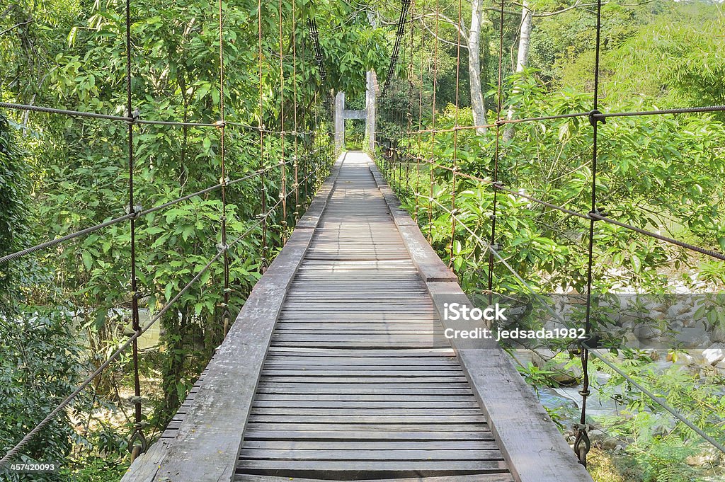 Wooden suspension bridge Pedestrian suspension bridge over river in forest. Adventure Stock Photo