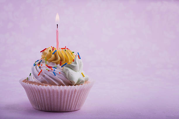 istock birthday cupcake with candle, on the pink 457421319