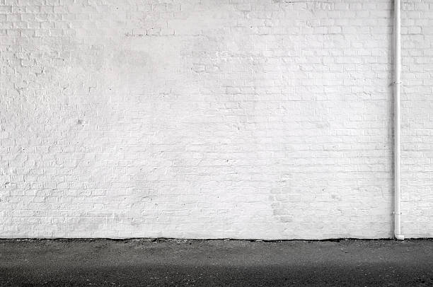 White Brick Wall And Sidewalk In An Urban Street- Background White brick wall with gutter. stucco photos stock pictures, royalty-free photos & images
