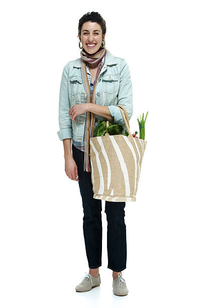Cheerful woman standing with vegetables bag