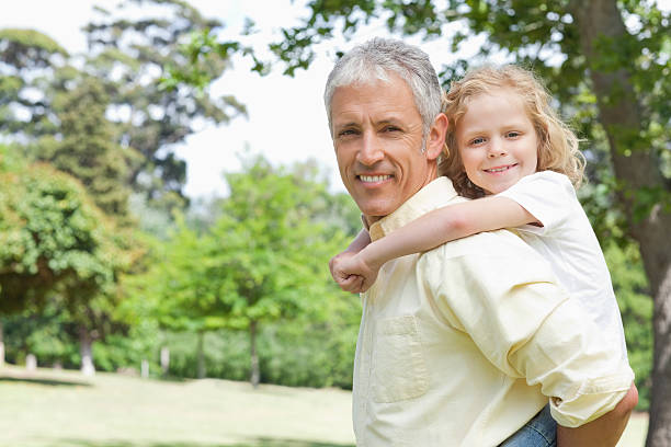 istock Father and son smiling at camera during a piggy-back 457424053