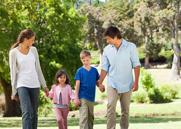 istock Young family are walking in a park holding hands 457425061