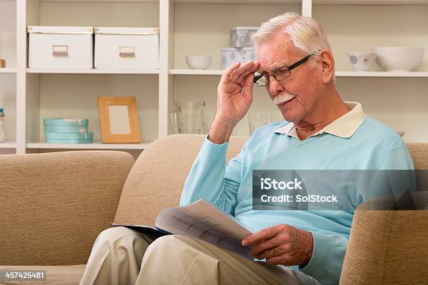 Senior Man Reading Adultos Foto de stock y más banco de imágenes de Acogedor - Acogedor, Adulto, Agarrar