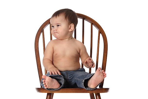 Cute baby boy sitting in a wooden chair