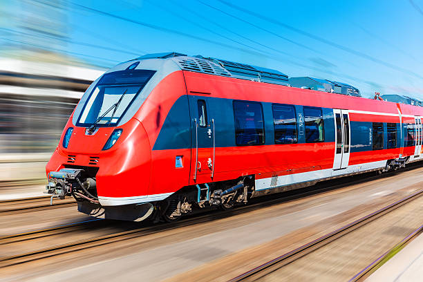 Red high-speed train with blurred motion Railroad travel and railway tourism transportation industrial concept: scenic summer view of modern high speed passenger commuter train on tracks with motion blur effect electric train photos stock pictures, royalty-free photos & images