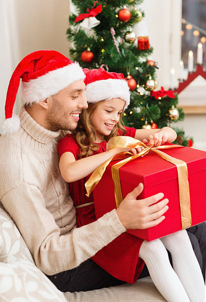 istock smiling father and daughter opening gift box 457437735