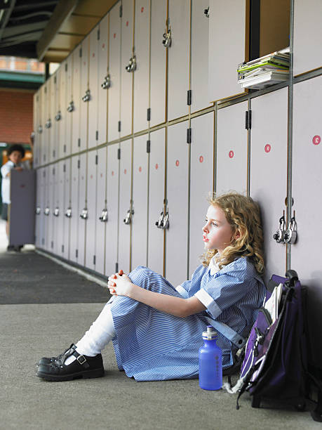 istock Girl Sitting Against School Lockers 457442623