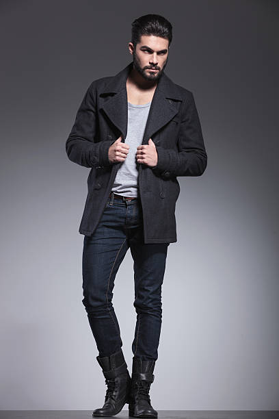 istock young man with long beard is holding his coat's collar 457444259