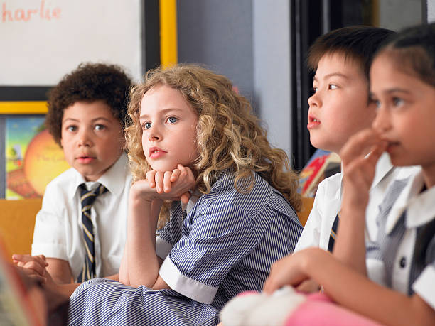Thoughtful Students Sitting In Classroom stock photo