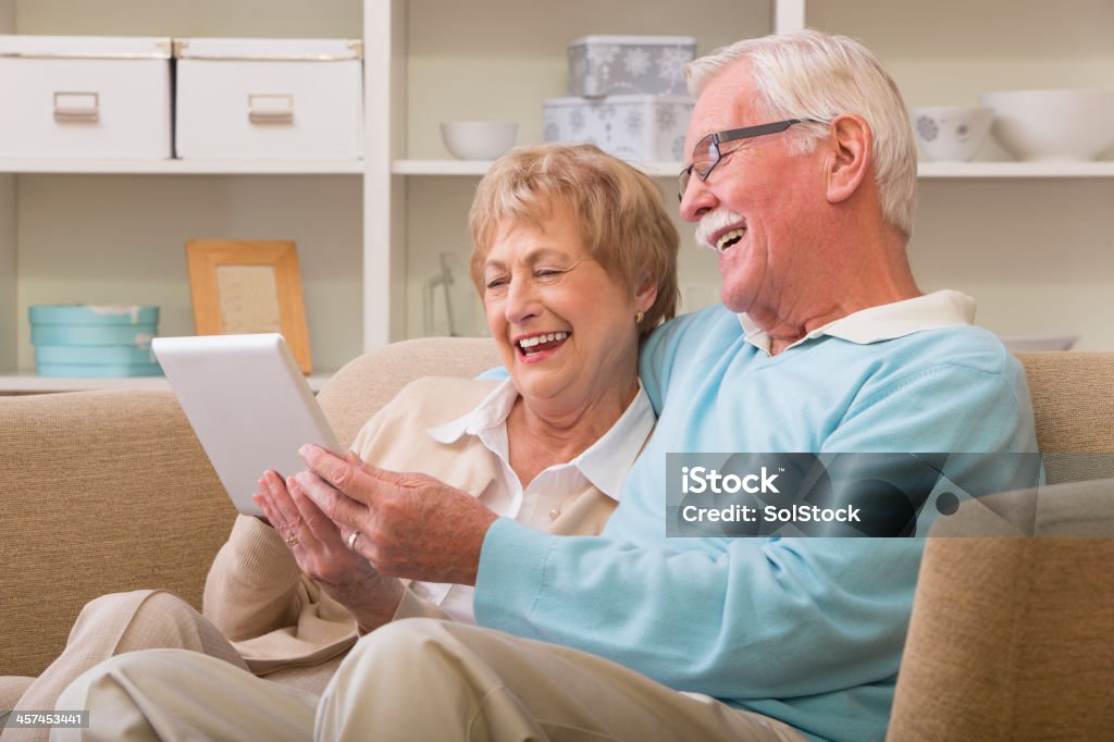 Anziani utilizzando la tecnologia - Foto stock royalty-free di Abbigliamento casual