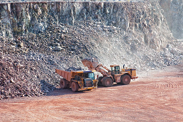 istock earth mover loading a dumper truck in surface mine quarry 457478533