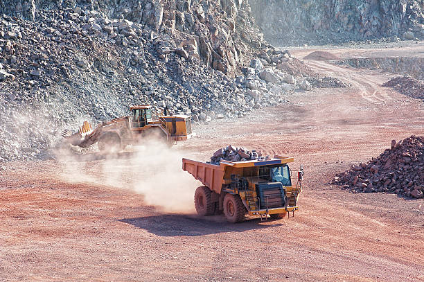 escavadora mecânica carregar um camião dumper em mina de superfície pedreira - hohe qualität imagens e fotografias de stock