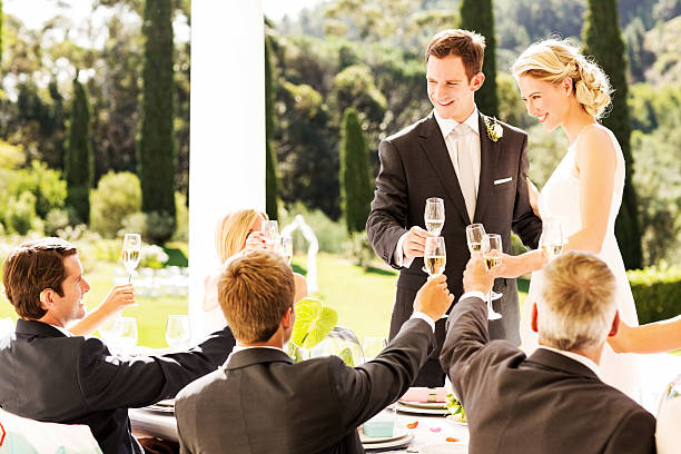 istock Newlywed Couple And Guests Toasting Together At Table 457489117