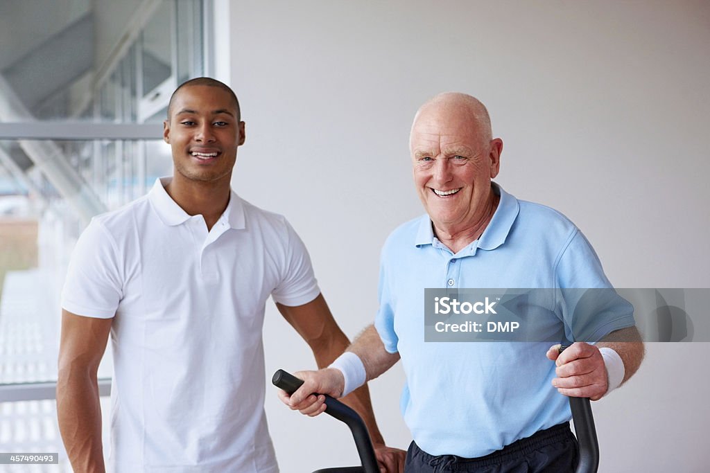 Active uomo anziano e fitness trainer in palestra - Foto stock royalty-free di 20-24 anni