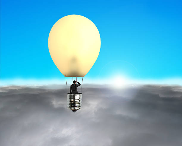 istock Man taking glowing lamp balloon flying over clouds 457516735